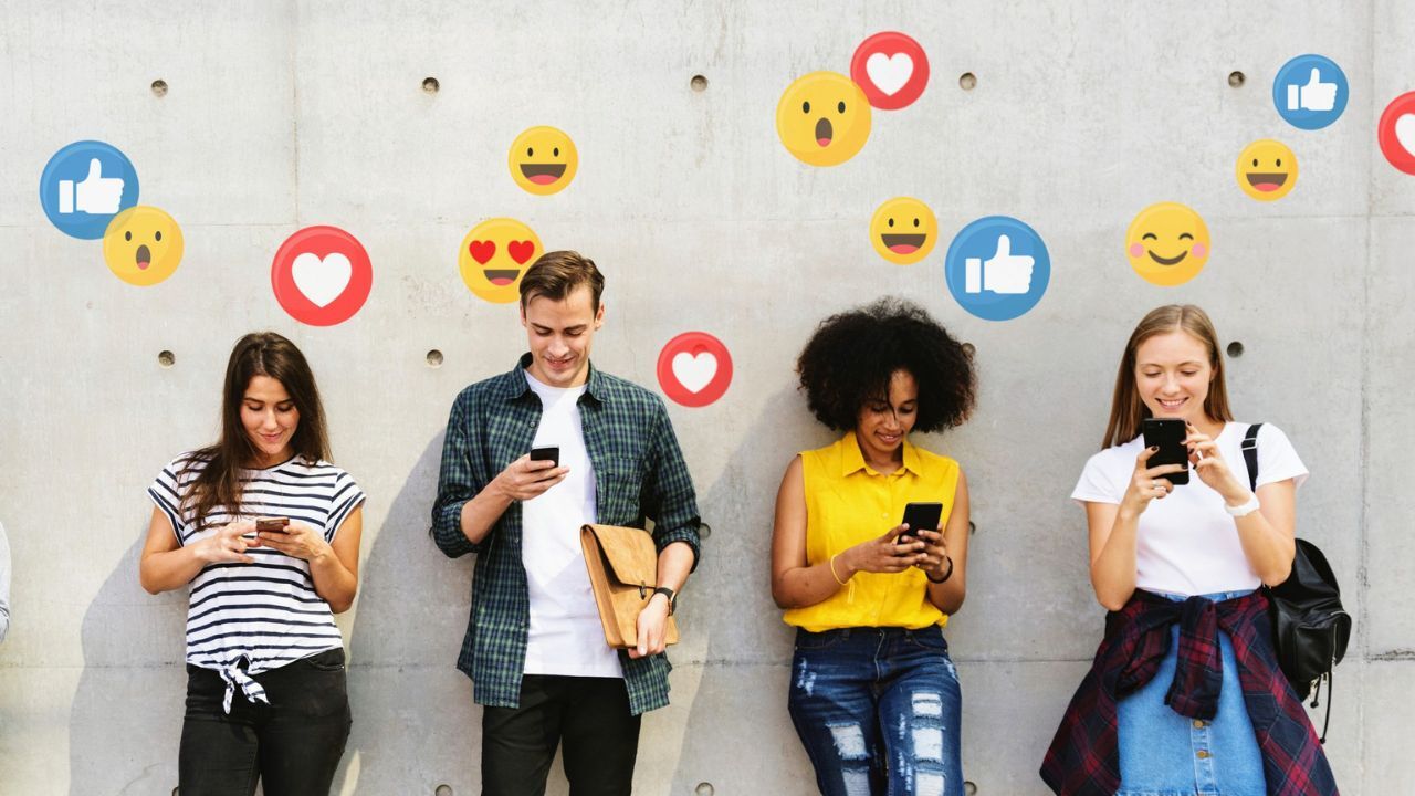 Skupina mladých lidí sleduje mobilní telefony, nad nimi se vznášejí reakce ze sociálních sítí jako symbol investičních mýtů ze sociálních sítí