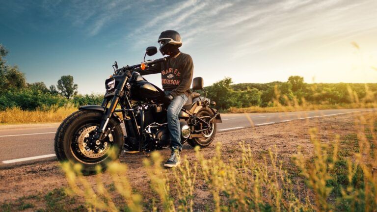 Motorkář na chopperu si užívá volnost na silnici při západu slunce. Po dni plném zatáček ocení kvalitní ubytování pro motorkáře s bezpečným parkováním.