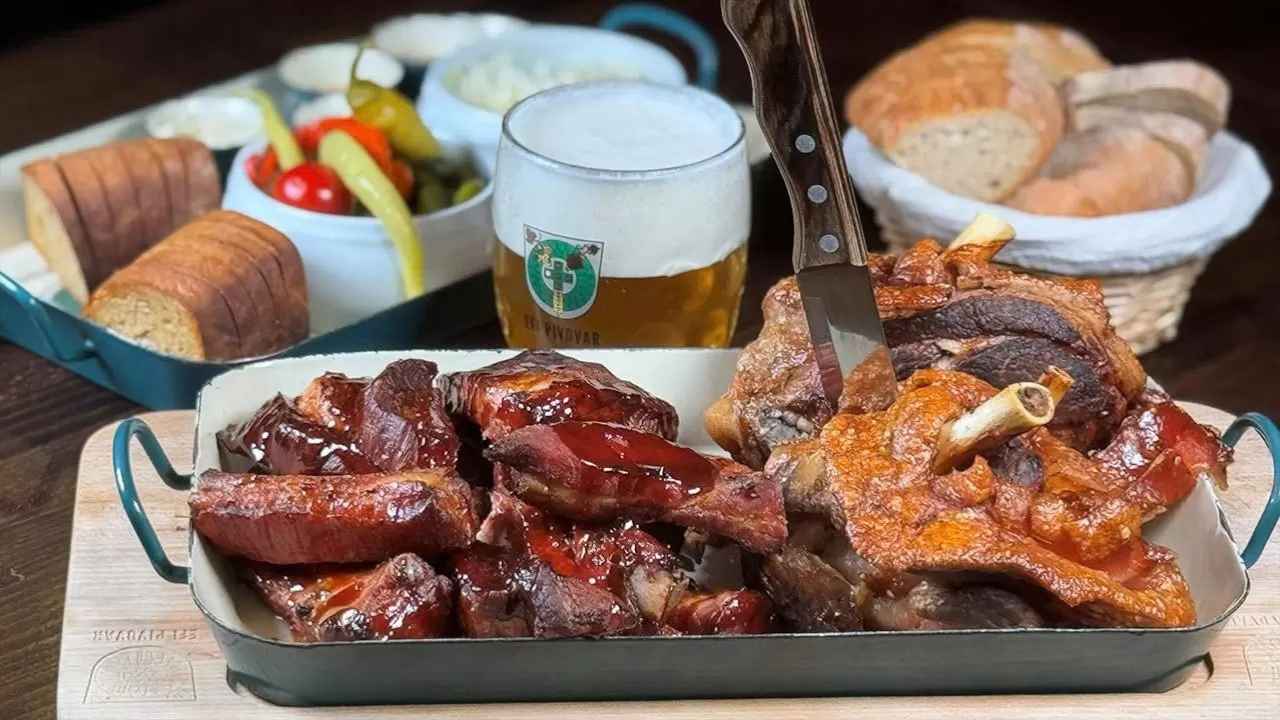Prkénko s masovými specialitami, pečivem, zeleninou a omáčkami z nabídky EFI Hostince.