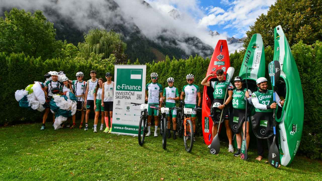Skupinová fotografie sportovců s kajaky v zázemí závodu Red Bull Dolomitenmann 2026.