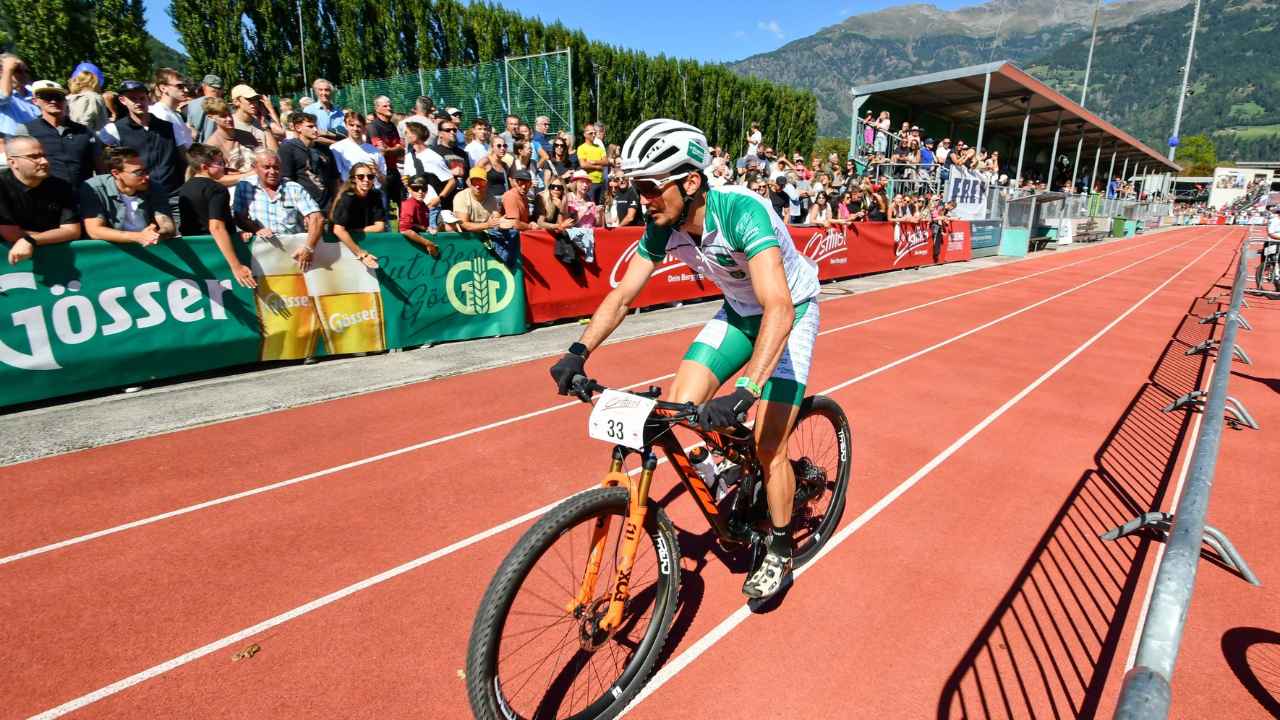 Cyklista na horském kole projíždí stadionem při závodě Red Bull Dolomitenmann 2026.