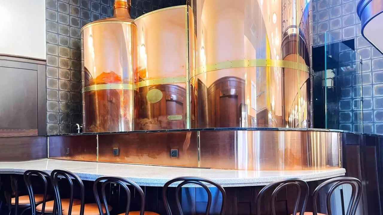 Interiér EFI Hostince Osmec v Brně s výčepem a posezením u stolů.