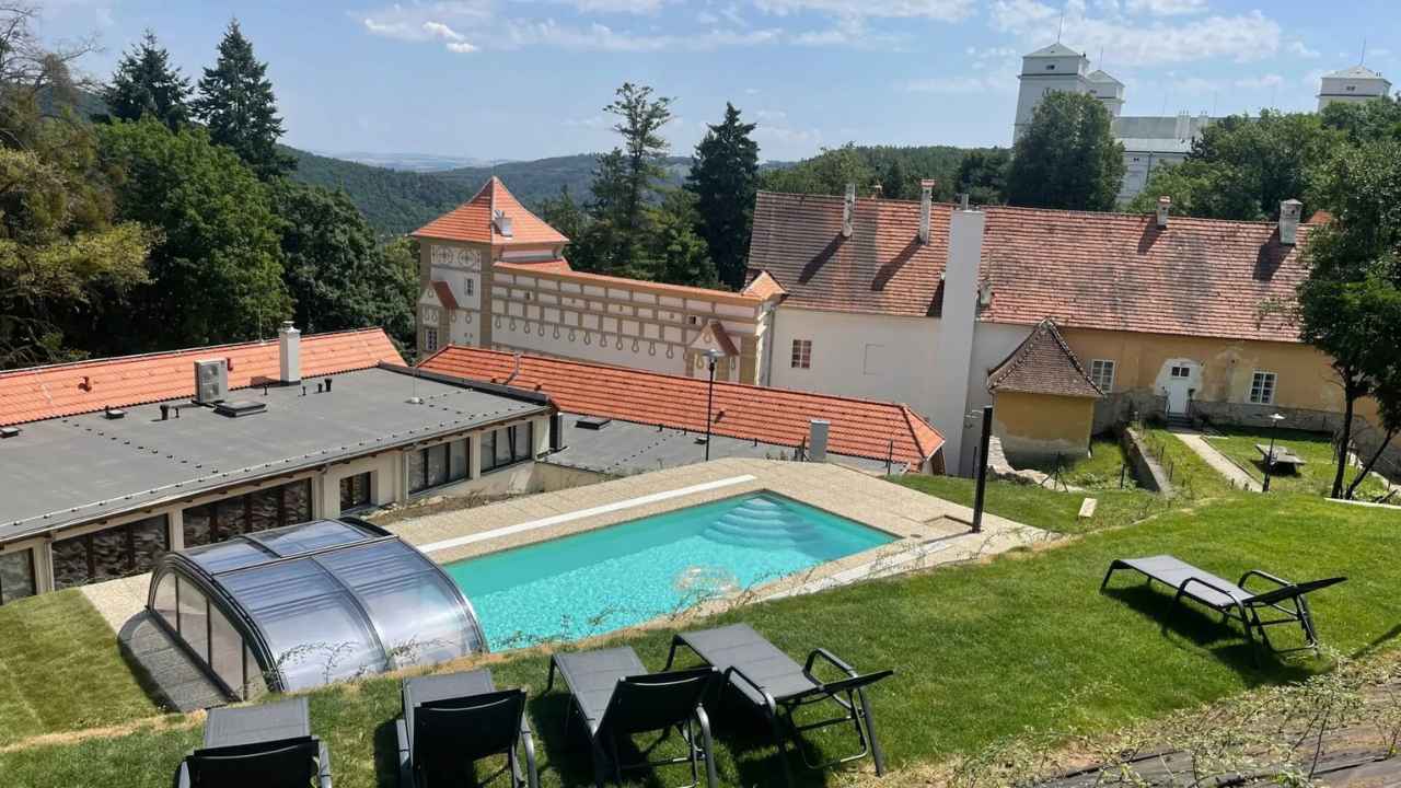 Wellness Zámek Račice: venkovní bazén s lehátky a zelení v Podzámčí
